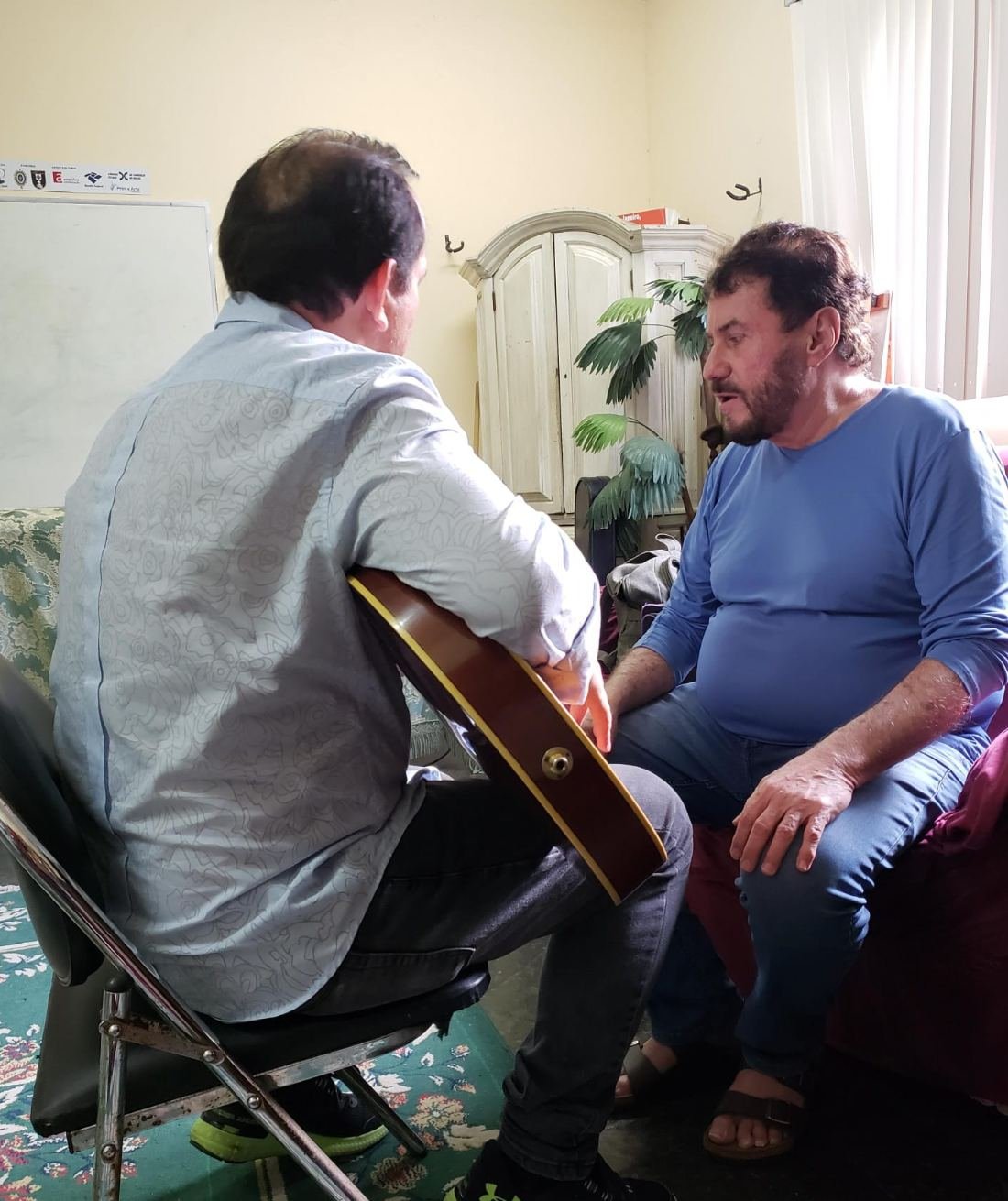 Antônio Carlos, da dupla Antônio Carlos e Jocafi, ensinando acordes de violão a Edilásio Jr.