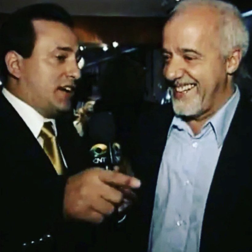Edilásio Jr. entrevista um escritor brasileiro, com microfone de mão, em imagem de arquivo do Programa Vip