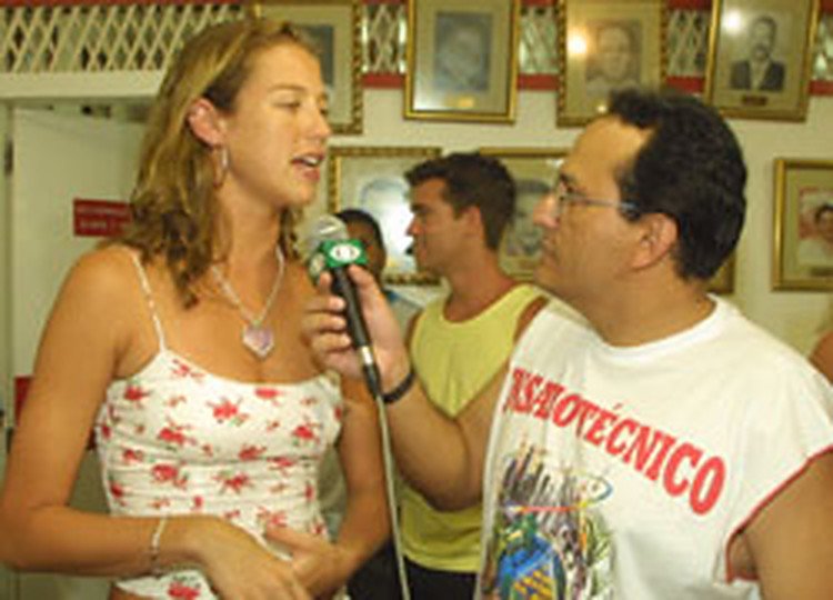Edilásio Jr. com microfone, em entrevista na escola de samba do Salgueiro